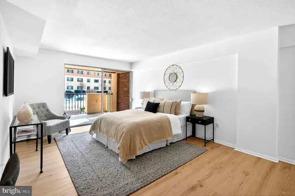 a bedroom with a bed a lamp and a large window