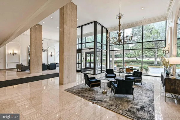 a living room with furniture large windows and wooden floor