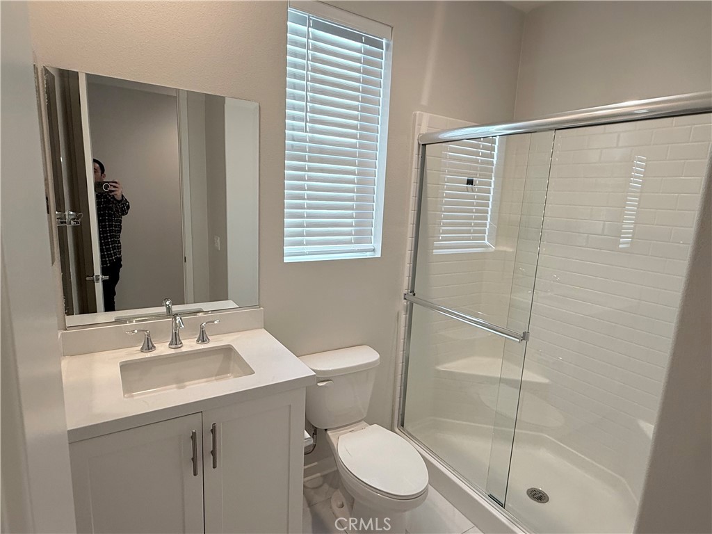 31124 Hanover Lane Menifee, CA 92584 - Photo 12 of 58 a bathroom with a shower a sink a toilet and mirror