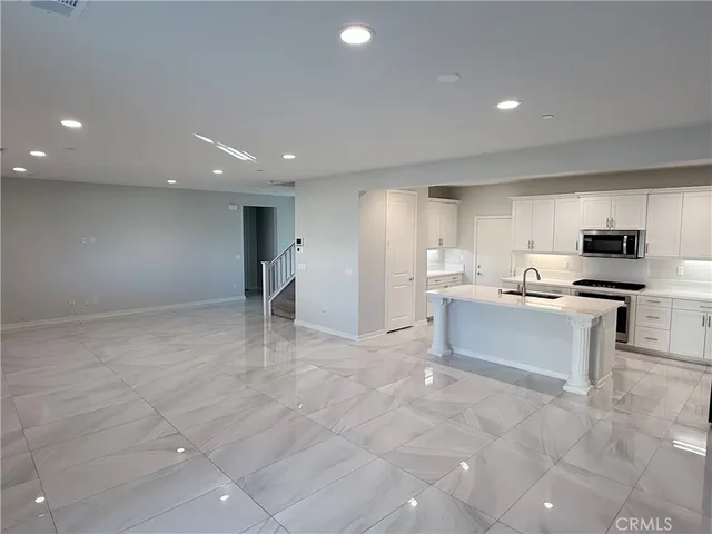 a kitchen with a sink a stove a refrigerator a sink and white cabinets