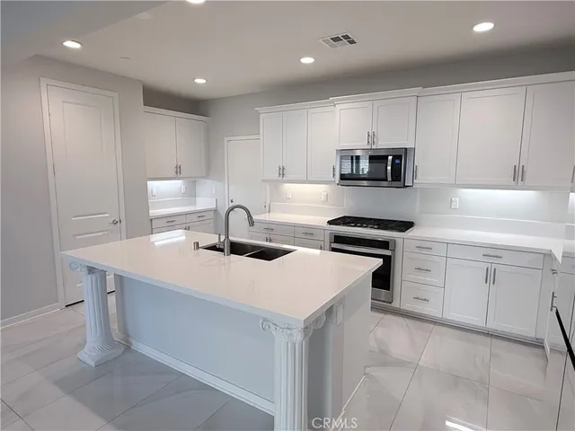 a kitchen with a sink a refrigerator and wooden cabinets