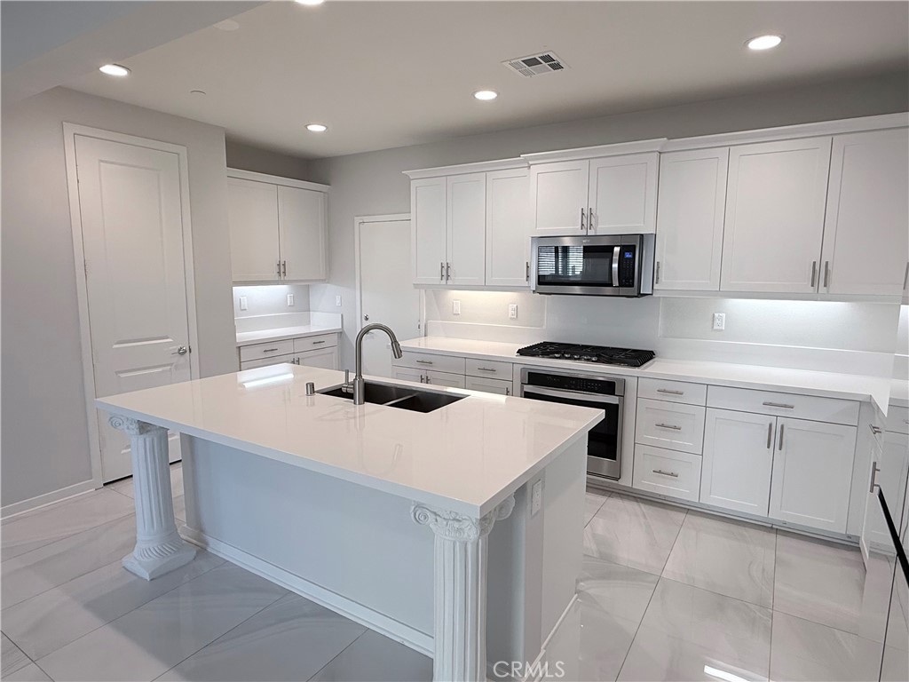 31124 Hanover Lane Menifee, CA 92584 - Photo 22 of 58 a kitchen with a sink a stove and cabinets
