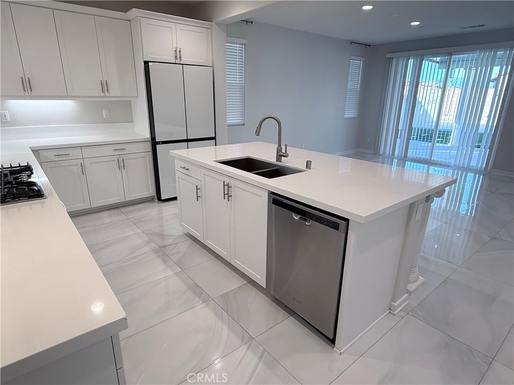 31124 Hanover Lane Menifee, CA 92584 - Photo 24 of 58 a kitchen with a sink a refrigerator and wooden cabinets