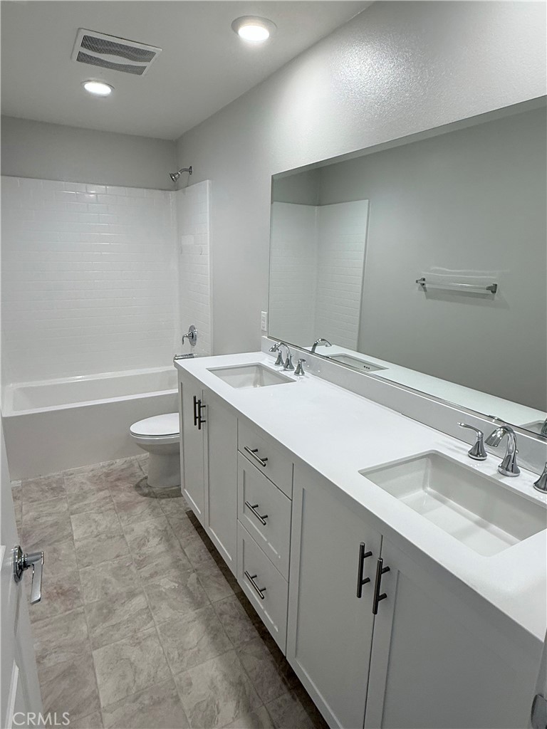 31124 Hanover Lane Menifee, CA 92584 - Photo 43 of 58 a bathroom with a double vanity sink toilet and a tub