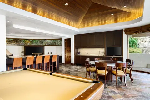 a living room with a floor to ceiling window and pool table