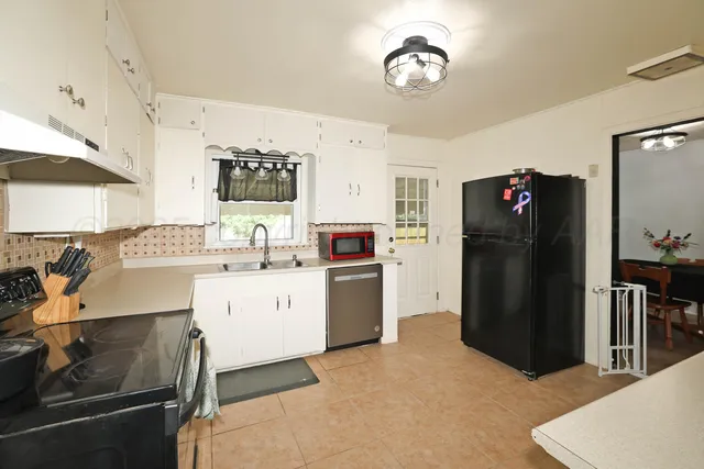 a kitchen with a refrigerator and a stove top oven