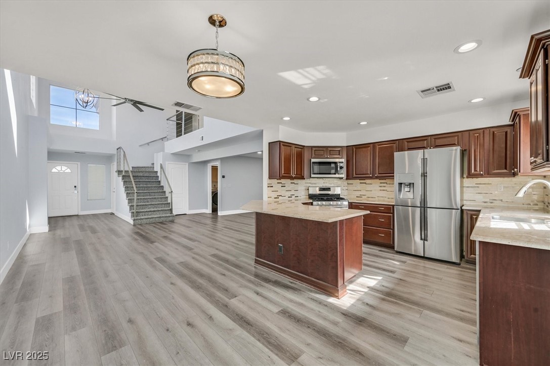 5421 Painted Mirage Road Las Vegas, NV 89149 - Photo 35 of 35 Kitchen with light wood finished floors, visible vents, appliances with stainless steel finishes, open floor plan, and a sink
