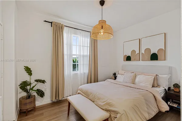 a bedroom with a bed and a potted plant