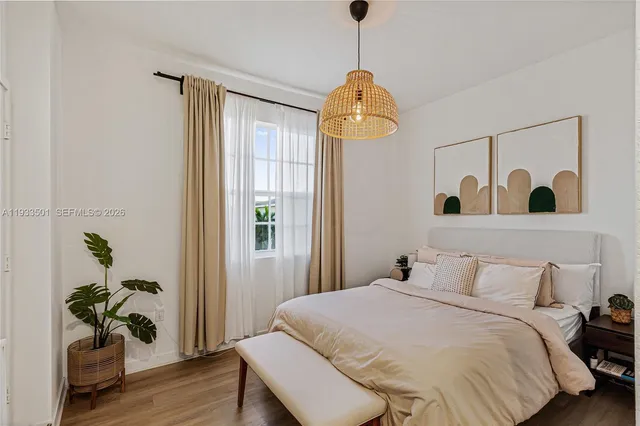 a bedroom with a bed and a potted plant