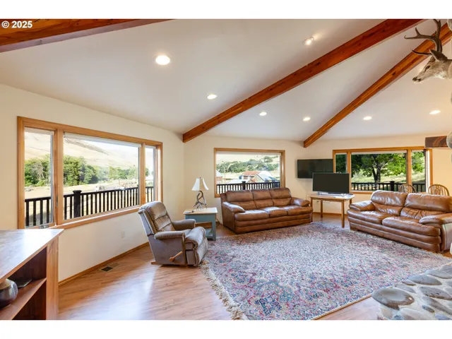 a living room with furniture and a fireplace with kitchen view
