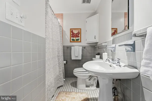 a bathroom with a sink toilet and a mirror