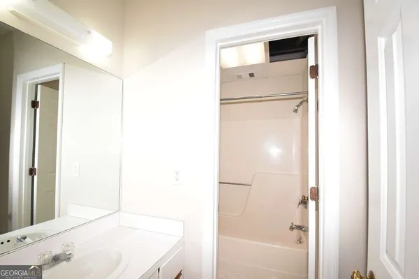 a bathroom with a white tub shower and vanity