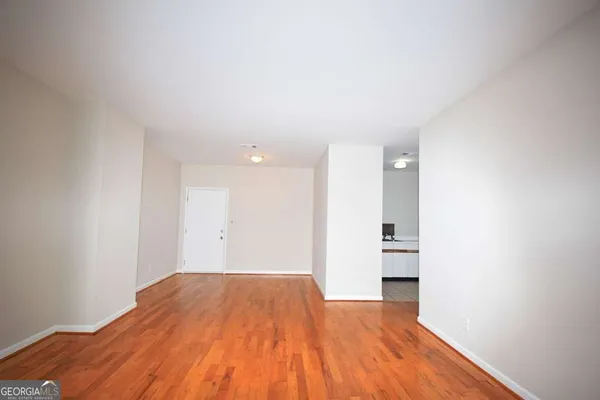 a view of empty room with wooden floor