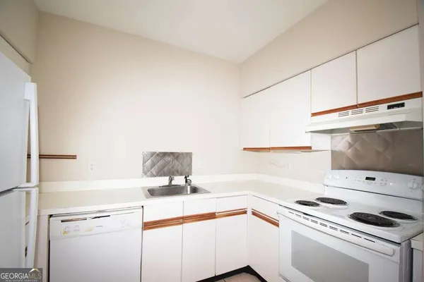 a view of a kitchen with stove and white cabinets
