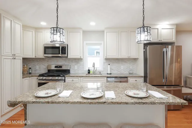 a kitchen with sink a dining table and chairs with wooden floor