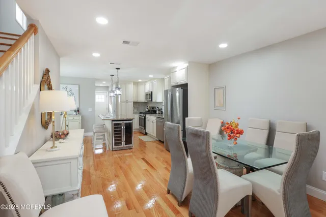 a living room with furniture and a dining table with wooden floor