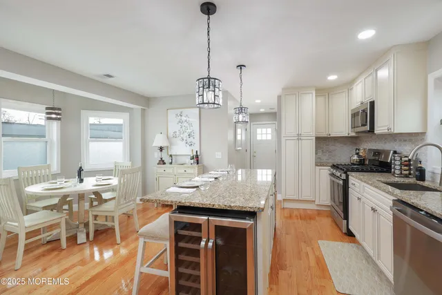 a kitchen with kitchen island granite countertop stainless steel appliances cabinets a sink and a center island