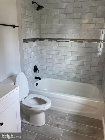 a white toilet sitting next to a bath tub