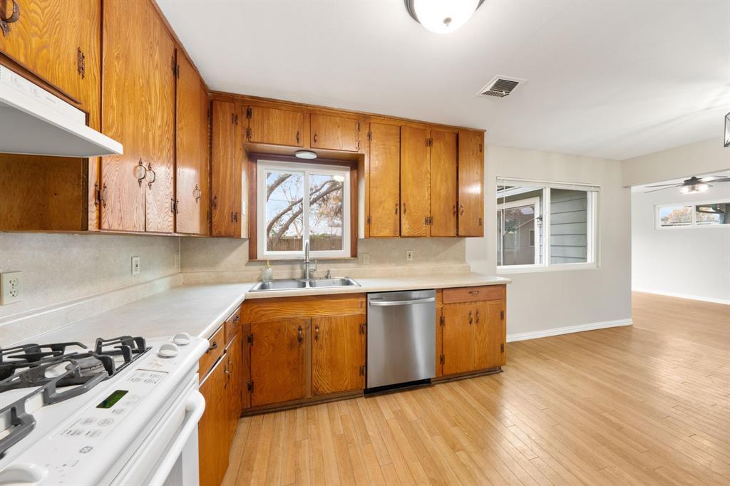 753 Cullum Avenue Hurst, TX 76053 - Photo 14 of 26 a kitchen with stainless steel appliances granite countertop a sink a stove and a wooden floors