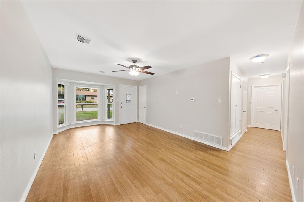 753 Cullum Avenue Hurst, TX 76053 - Photo 4 of 26 an empty room with wooden floor and windows