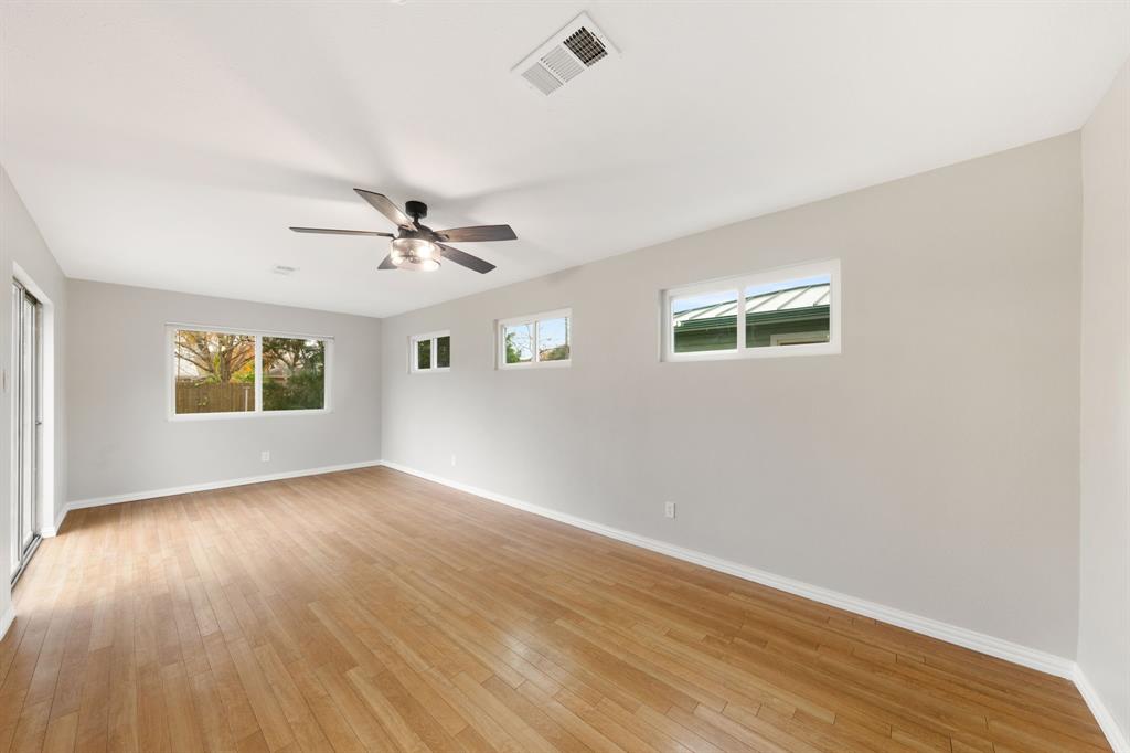 753 Cullum Avenue Hurst, TX 76053 - Photo 7 of 26 an empty room with wooden floor ceiling fan and windows