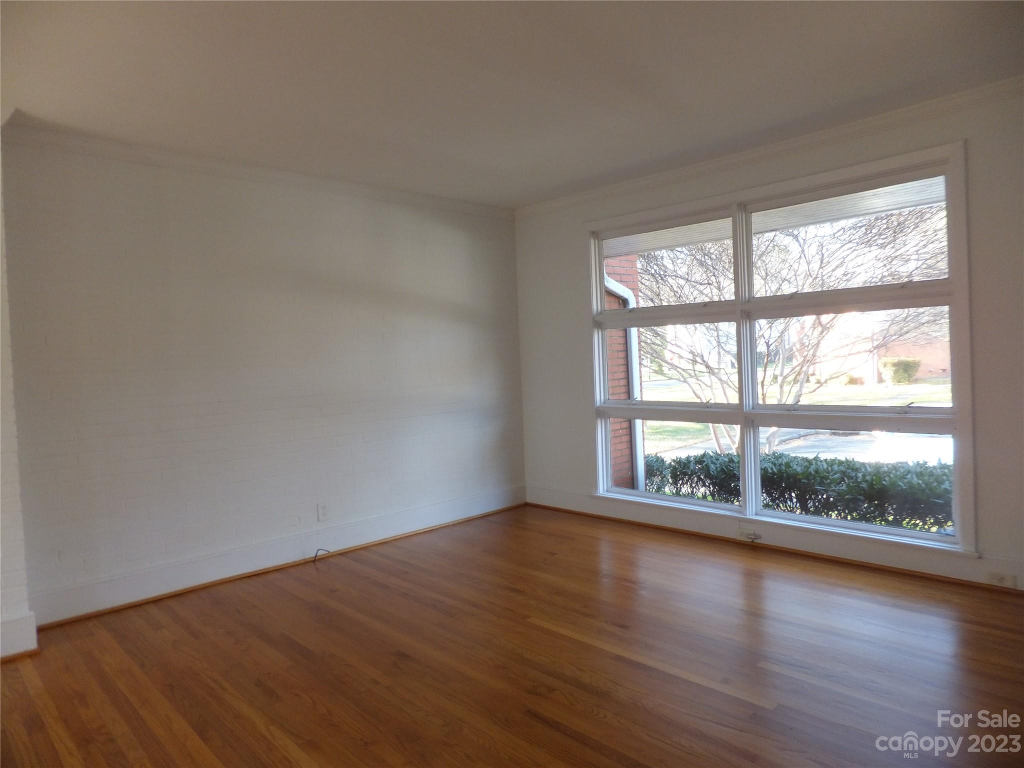 4222 Randolph Road Charlotte, NC 28211 - Photo 3 of 18 a view of an empty room with wooden floor and a window