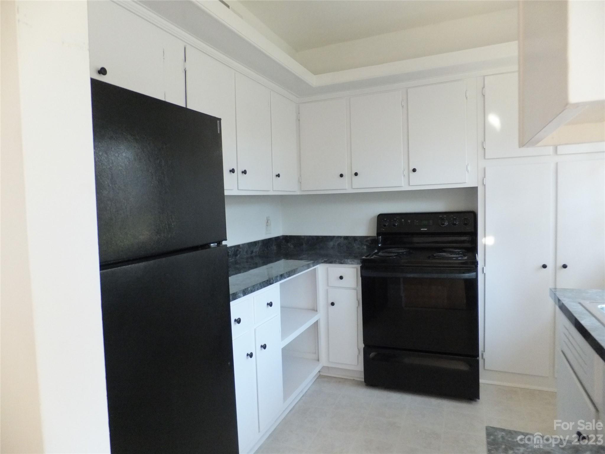4222 Randolph Road Charlotte, NC 28211 - Photo 7 of 18 a kitchen with a refrigerator and white cabinets