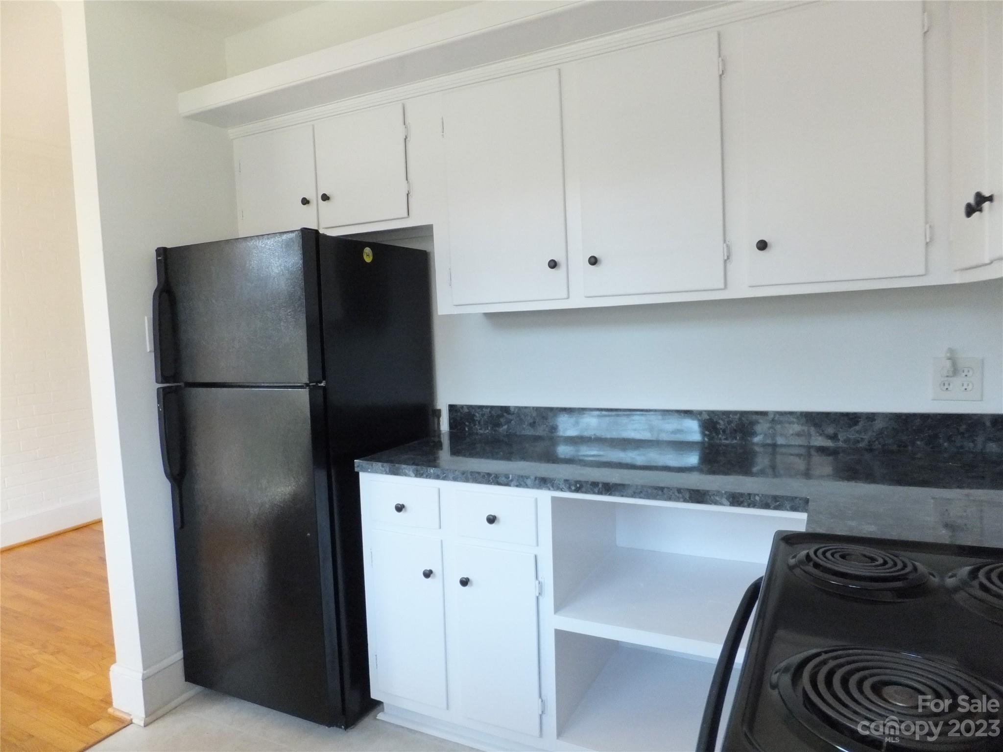 4222 Randolph Road Charlotte, NC 28211 - Photo 8 of 18 a kitchen with granite countertop white cabinets and refrigerator
