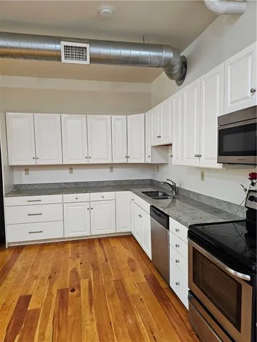 a kitchen with granite countertop wooden cabinets and a stove top oven
