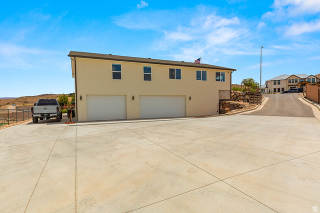 2591 East Washington Dam Road Washington, UT 84780 - Photo 54 of 67 Two-story stucco property featuring a concrete driveway, two garage doors, and upper-level windows