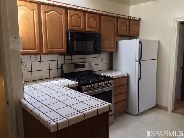 22 Shawnee Avenue San Francisco, CA 94112 - Photo 12 of 21 a kitchen with stainless steel appliances a stove a microwave a sink and cabinets