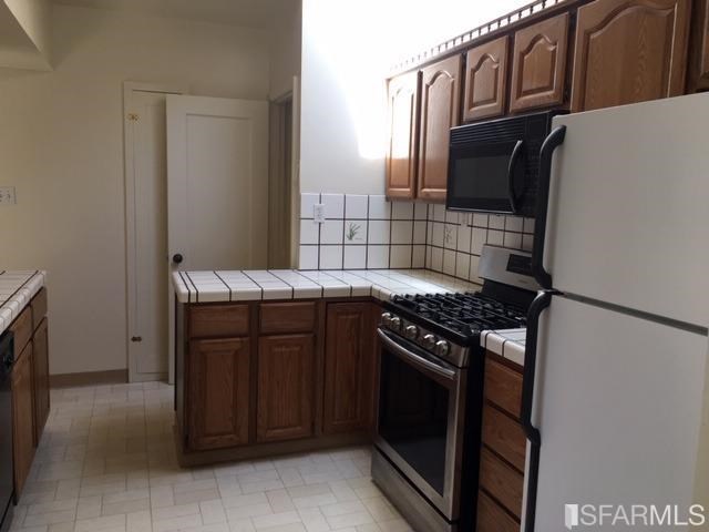 22 Shawnee Avenue San Francisco, CA 94112 - Photo 13 of 21 a kitchen with granite countertop a stove and a refrigerator