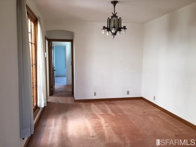 22 Shawnee Avenue San Francisco, CA 94112 - Photo 19 of 21 an empty room with a chandelier fan and windows