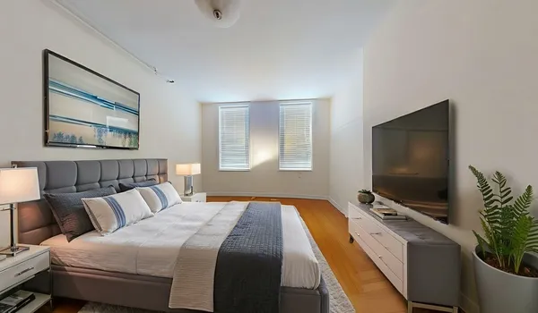 a bedroom with bed tv and window