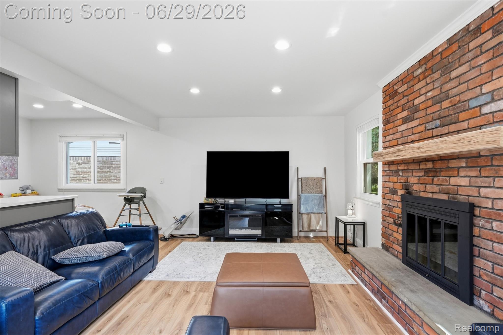 45179 Rudgate Road Canton, MI 48188 - Photo 9 of 48 Living area featuring a brick fireplace with a wood mantel, a stone hearth, recessed lighting, and wood-finish flooring