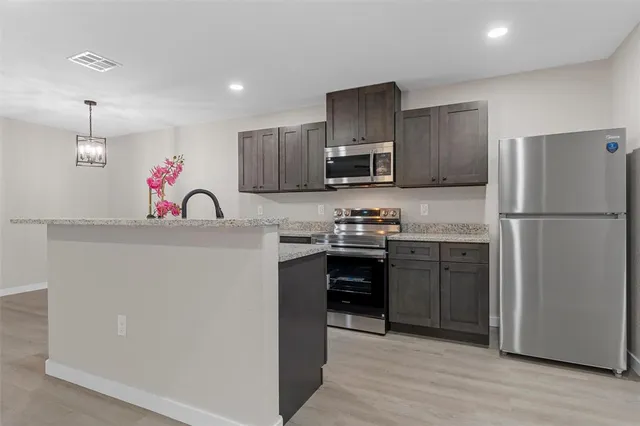 a kitchen with stainless steel appliances a refrigerator stove and sink