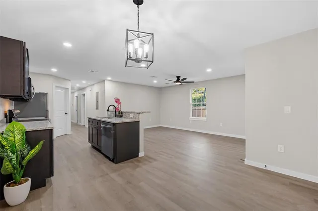 a room with wooden floors and ceiling fan