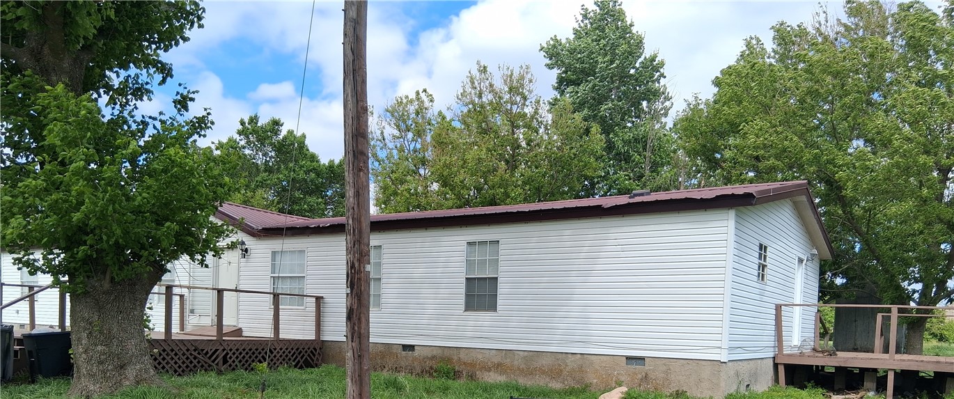 910 Sands Road Cave Springs, AR 72718 - Photo 1 of 11 White vinyl siding, brown metal roof, and a wooden deck