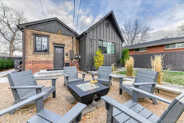 a view of a patio with couches table and chairs with wooden floor and fence