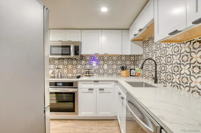 a kitchen with stainless steel appliances a sink stove and cabinets