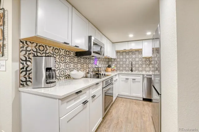 a kitchen with white cabinets and white appliances