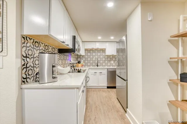 a kitchen with a refrigerator a sink and wooden floor