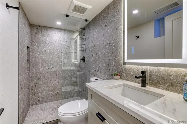 a bathroom with a sink a toilet and shower