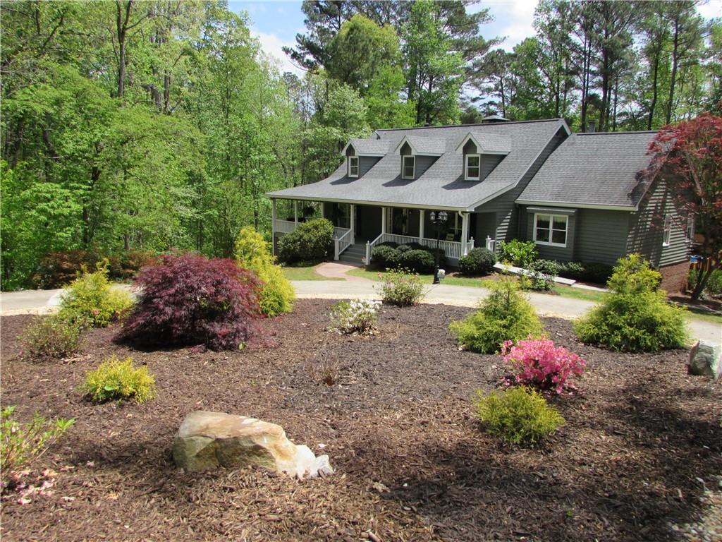 1235 Riverside Road Sugar Hill, GA 30518 - Photo 1 of 1 a view of a house with a yard and lawn chairs under an umbrella