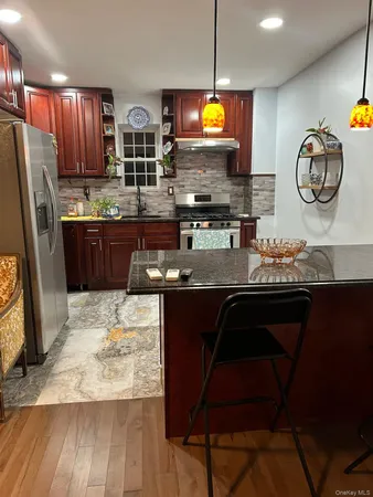 a kitchen with stainless steel appliances granite countertop a stove refrigerator and a microwave