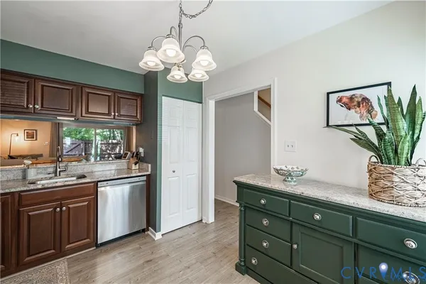 a kitchen with stainless steel appliances granite countertop cabinets a sink and a potted plant
