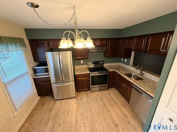 a kitchen with granite countertop a stove oven and refrigerator