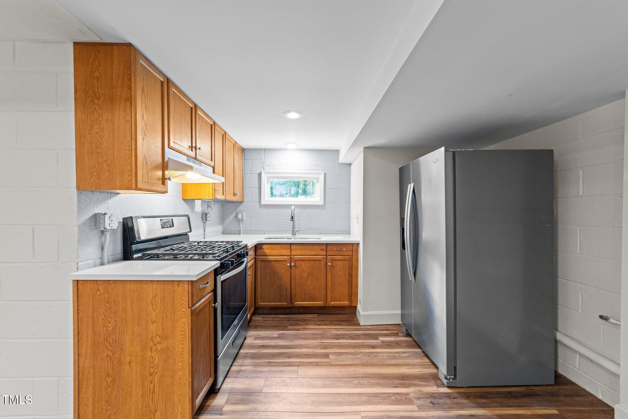 3309 Bearskin Court Raleigh, NC 27606 - Photo 24 of 40 a kitchen with stainless steel appliances granite countertop a refrigerator a stove a sink and a microwave