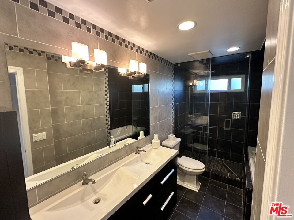 2721 2nd Street, Unit 207 Santa Monica, CA 90405 - Photo 4 of 11 a bathroom with a double vanity sink toilet and shower