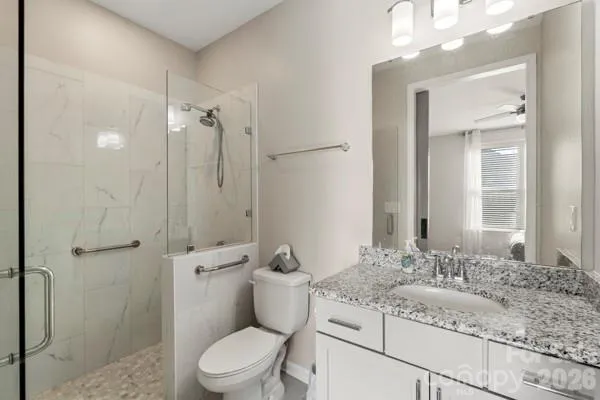 a bathroom with a granite countertop sink a toilet and shower